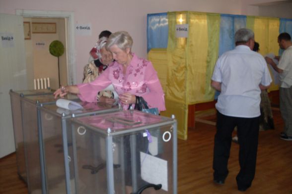 На дільниці працюють чотири кабінки. Є прозорі урни, куди виборці кидають бюлетені
