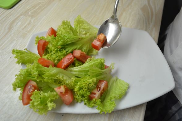 Збризкати салат оливковою олією і бальзамічним оцтом, викласти помідор