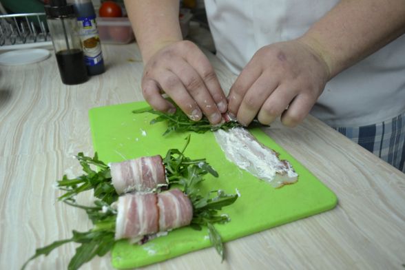 Покласти пучок руколи впоперек бочка і згорнути разом із начинкою рулетиком