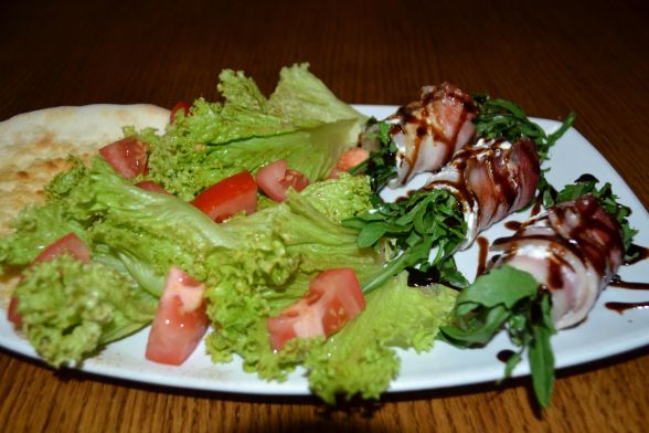 Поряд із салатом викласти рулетики з бочка, а також шматок паляниці — фокачо